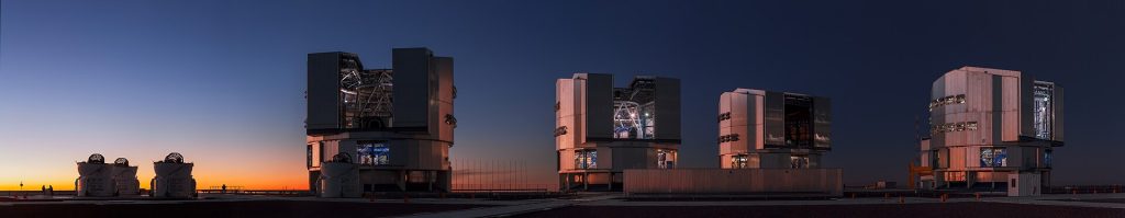 A large observatory telescope under a starry night sky